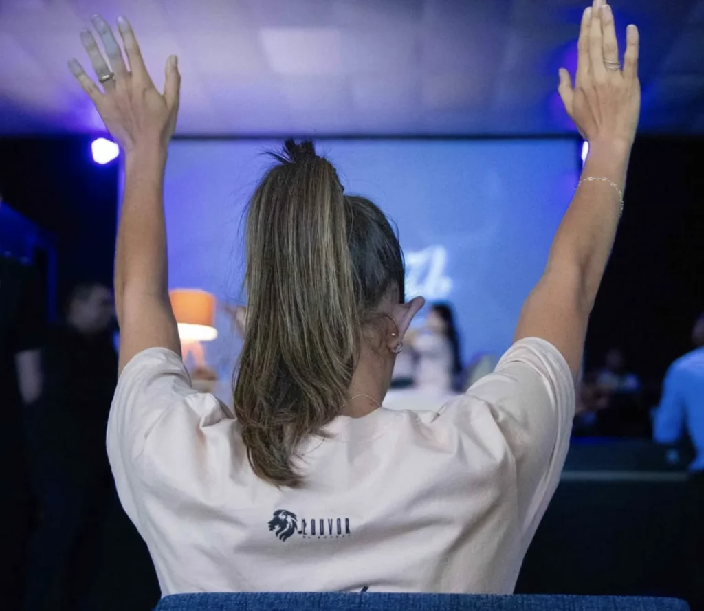 Ministério de Louvor El Shaday Parnaíba Ministerios: Fiel da Igreja El Shaday Parnaíba com as mãos levantadas vestindo a camiseta do Ministério de Louvor