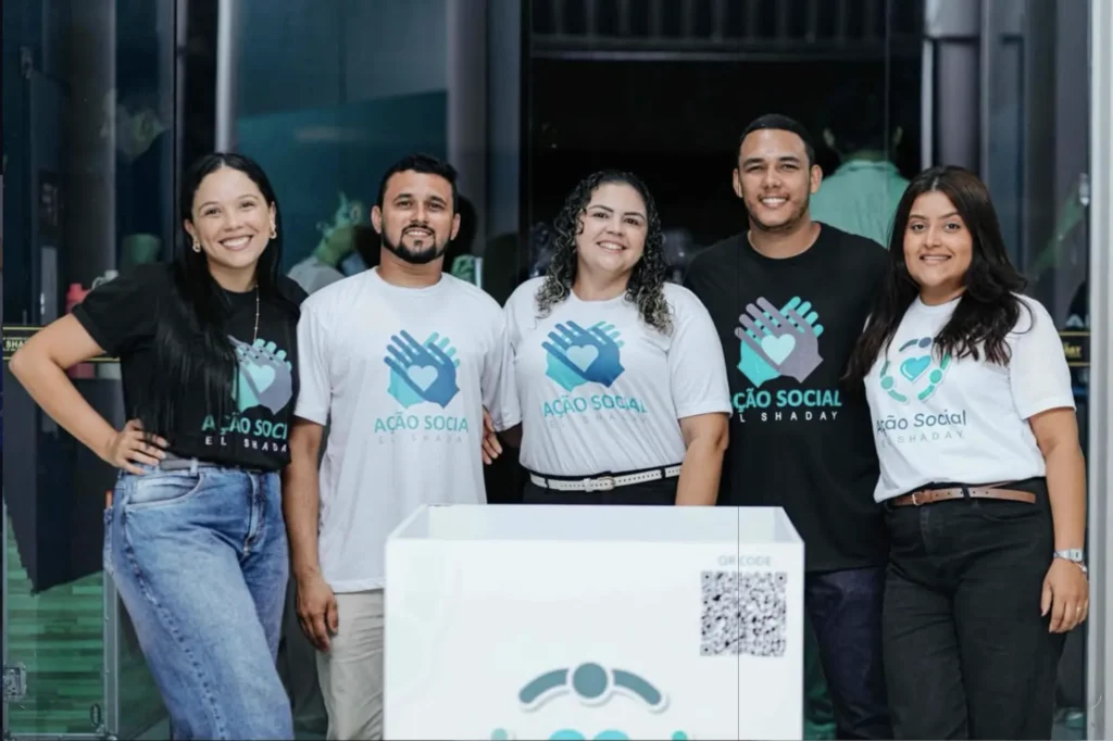 Ação Social El Shaday: Fé que Transforma Parnaíba Voluntários da Ação Social da Igreja El Shaday Parnaíba sorrindo e usando uniformes do projeto de assistência comunitária.